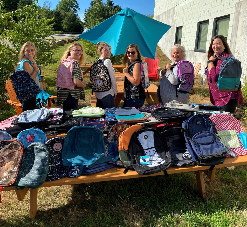 A photo of HSEM staff members and backpacks that were donated to charity.