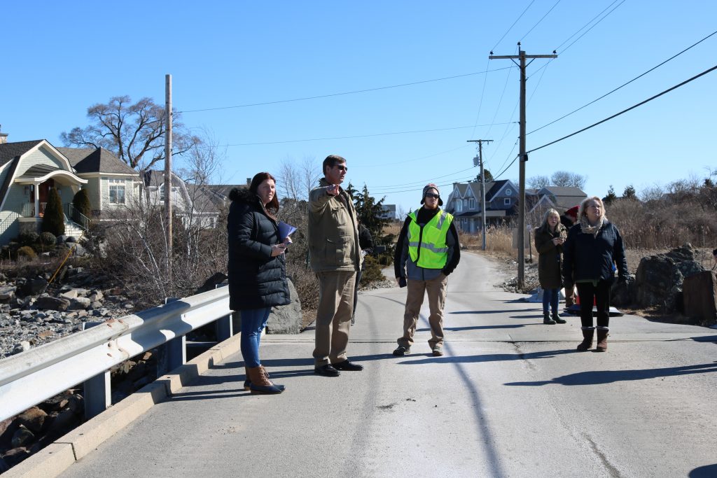 A photo of staff members from FEMA, HSEM and the town of Rye standing in the middle of the road on a bridge.